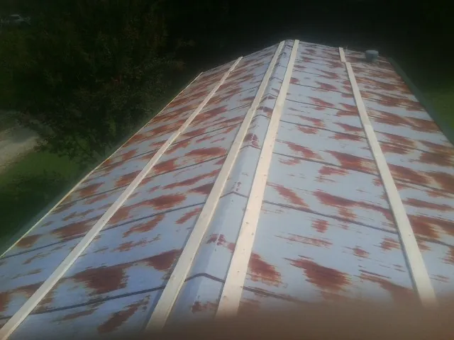 Rusted metal roof panels with new wood purlins before replacement — Storm Damage Roof Repair in Advance by Roofing Brothers