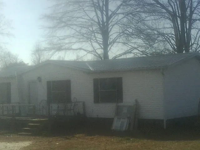 New metal roof on a white painted brick home on a foggy morning in Advance
