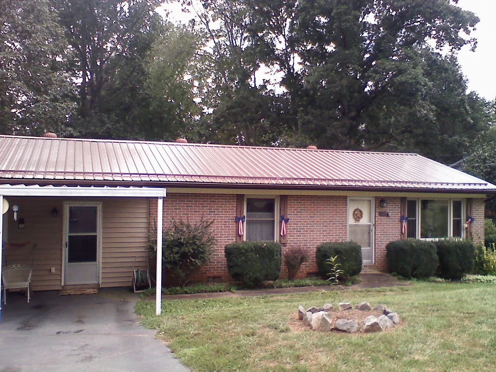 Bronze metal roof and carport on a brick ranch home — Roof Repair work by our crew in Advance